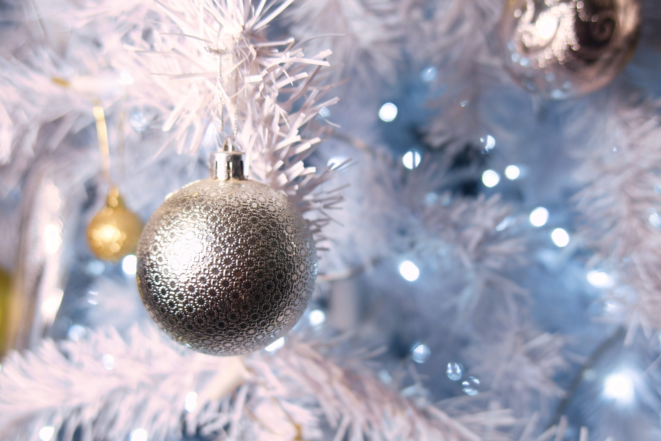 Shiny gold and silver christmas spheres on christmas tree with space for text